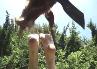 Pretty zoophile lady shows her feet to a goat